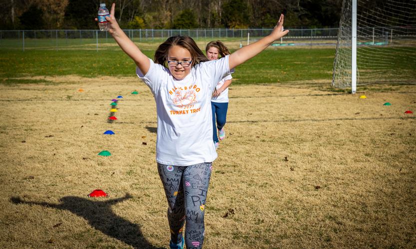 A student celebrates while running